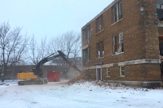 L'entrepreneur en démolition EDC Construction démolie une école avec un brise-roches d'excavatrices