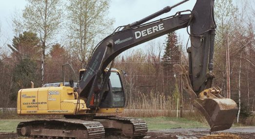 Pelle mécanique qui démolie une piscine creusée.